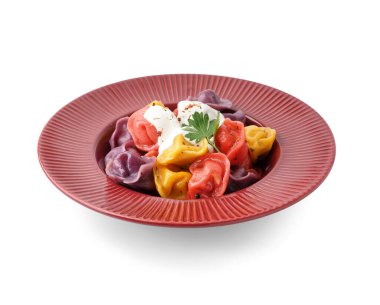 Beyaz arka planda ekşi kremalı ve maydanozlu kaynamış renkli hamur köfteleri.