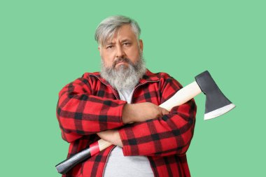 Yeşil arka planda baltası olan olgun oduncunun portresi