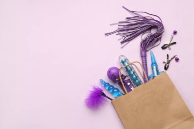 Mor arka planda farklı seks oyuncakları olan bir alışveriş çantası.