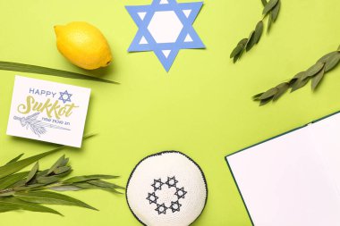 Dört türden (lulav, hadas, arava, etrog) yapılmış çerçeve Sukkot festival sembolleri, tebrik kartı ve yeşil arkaplan üzerine kağıt David yıldızı