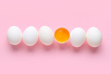 Pembe arka planda çiğ tavuk yumurtası.