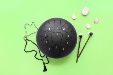 Çubuklu glukofon, yeşil arka planda spa taşları ve boncuklar