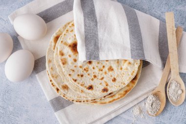 Beyaz arka planda lezzetli pita ekmeği, yumurta ve un.