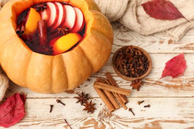 Balkabağında lezzetli şarap ve beyaz ahşap arka planda malzemeler.