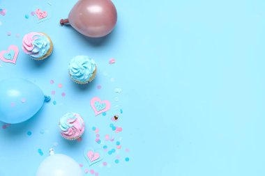 Soru işaretli lezzetli kekler, balonlar ve mavi arka planda konfeti. Cinsiyet ortaya çıkan parti kavramı