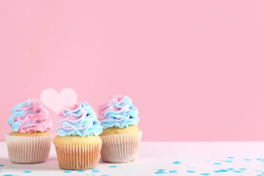 Pembe arka planda konfetisi olan enfes kekler. Cinsiyet ortaya çıkan parti kavramı