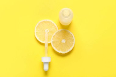 Sarı zemin üzerinde limon dilimleri olan bir şişe C vitamini.