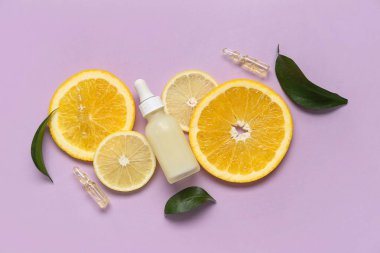 Leylak arka planında narenciye dilimleri olan C vitamini şişesi ve ampule.