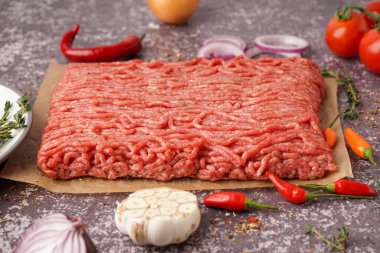 Gri arka planda baharatlı taze kıyma.