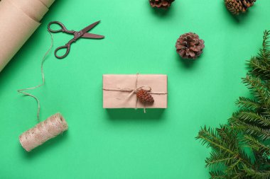 Noel hediyesi kutulu çam kozalakları ve yeşil arka planda köknar dalları