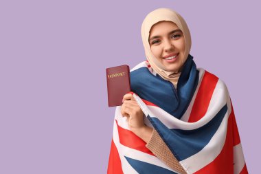 Mor arka planda İngiliz bayrağı ve pasaportu olan güzel bir Müslüman kadın.