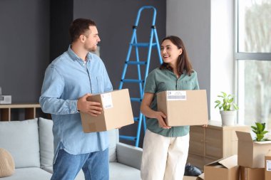 Taşındığı gün odada karton kutuları olan mutlu genç çift.
