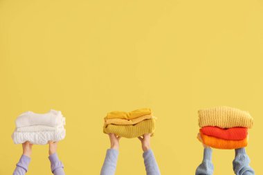 Sarı arka planda katlanmış süveterli kadınlar