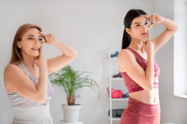 Fizyoterapisti olan güzel, mutlu, olgun bir kadın rehabilitasyon merkezinde yüz geliştirme egzersizi yapıyor.