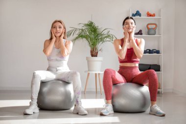 Fizyoterapistli güzel olgun bir kadın rehabilitasyon merkezinde vücut geliştirme egzersizi yapıyor.