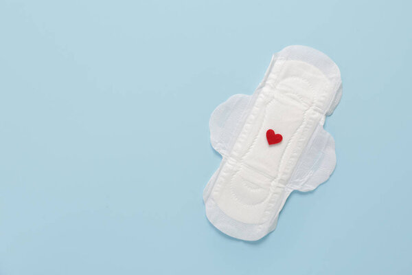 Менструальная прокладка с красным сердцем на синем фоне