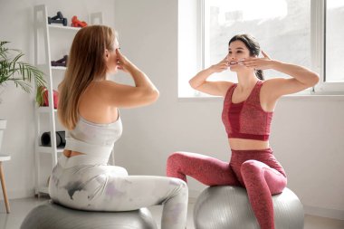 Fizyoterapistli güzel, mutlu, olgun bir kadın rehabilitasyon merkezinde vücut geliştirme egzersizi yapıyor.