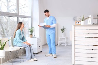 Klinikte bekleyen bir hastası olan bir resepsiyonist.