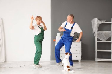 Onarım sırasında köpek dansı yapan olgun bir çift dekoratör.