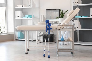 Koltuk ve koltuk değnekleriyle tıp bürosunun içinde.