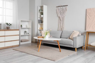 Oturma odasının içinde kanepe ve masa var.