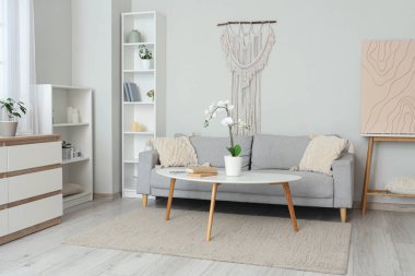 Oturma odasının içinde kanepe ve masa var.