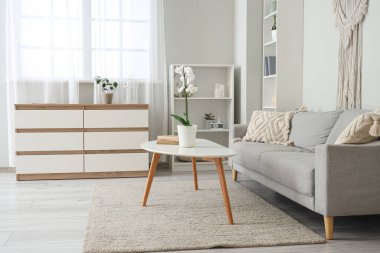 Oturma odasının içinde kanepe ve masa var.