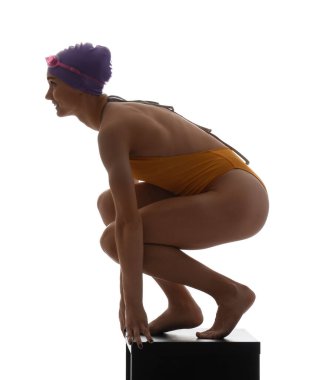 Genç bayan yüzücü beyaz arka planda sıçrama tahtasında