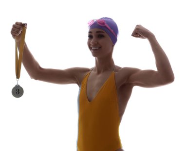 Üçüncü olan mutlu genç bayan yüzücü beyaz arka planda kaslarını gösteriyor.