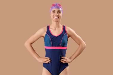 Bej arka planda mutlu genç bayan yüzücü