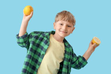 Mavi arka planda limonları olan şirin bir çocuk.