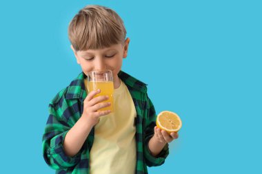 Mavi arka planda limonata ve bir bardak limonata olan şirin bir çocuk.