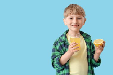 Mavi arka planda limonata ve bir bardak limonata olan şirin bir çocuk.