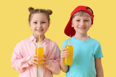 Sarı arka planda limonata şişeleri olan sevimli çocuklar.