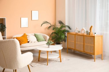 Beyaz kanepeli açık oturma odası, çekmeceler, koltuklar ve perdeler.