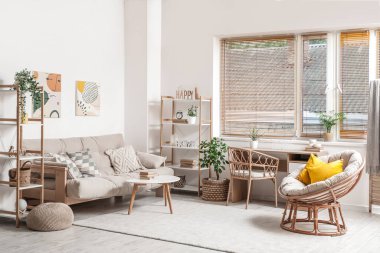 Koltuğu, koltuğu ve masaları olan bir oturma odası.