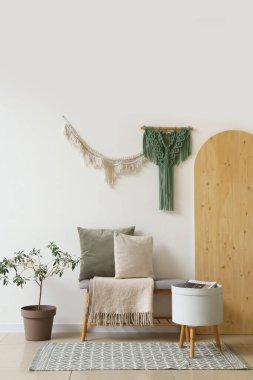 Yumuşak bank ve duvar halılarıyla aydınlık oturma odasının içinde.