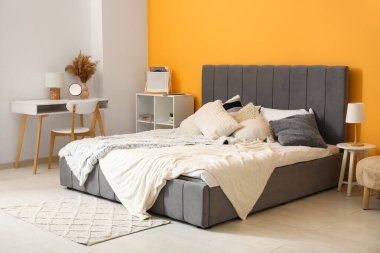 Yatağı, yatağı ve çalışma yeri olan modern bir yatak odası.