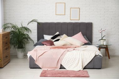 Yatak odası, komodinli yatak odası, çiçek ve ahşap çekmeceler.