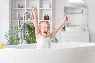 Banyoda banyo yaparken sabun köpüğüyle oynayan tatlı küçük kız.