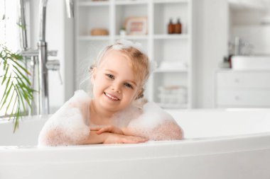 Köpüklü şirin kız banyoda banyo yapıyor.
