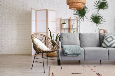 Interior of living room with sofa, armchair and folding screen