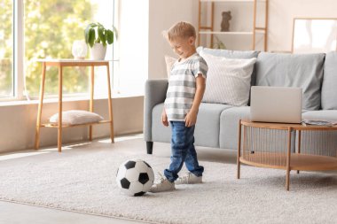 Evde futbol oynayan sevimli küçük çocuk.