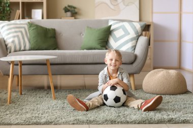 Evde futbol topu olan sevimli bir futbolcu.