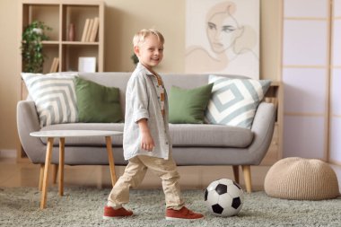 Evde futbol topu olan sevimli bir futbolcu.