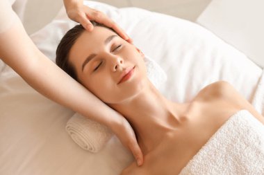 Kaplıca salonundaki kanepede masaj yaptıran genç bir kadın.