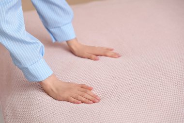 Yatak odasında yatak yapan genç kadın, yakın plan.