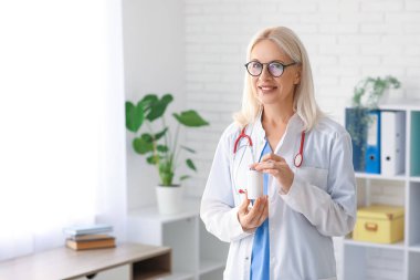 Klinikte ilaç şişesi olan kadın doktor.