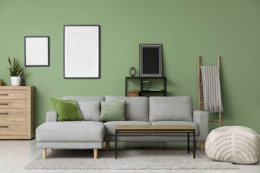 Gri kanepesi, masası ve çerçeveleri olan şık bir oturma odası.