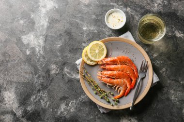 Lezzetli haşlanmış karides ve koyu arkaplanda limon tabağı.